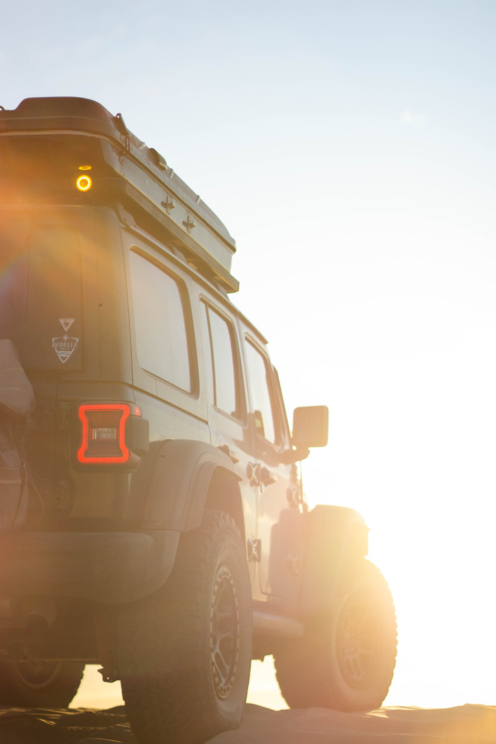 Image of a Jeep Wrangler from the passenger side at sunset